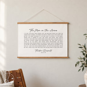 A black and white inspirational quote by Theodore Roosevelt, "The Man in the Arena", printed on a canvas tapestry. The quote is about the importance of taking action and striving for greatness, even in the face of failure.