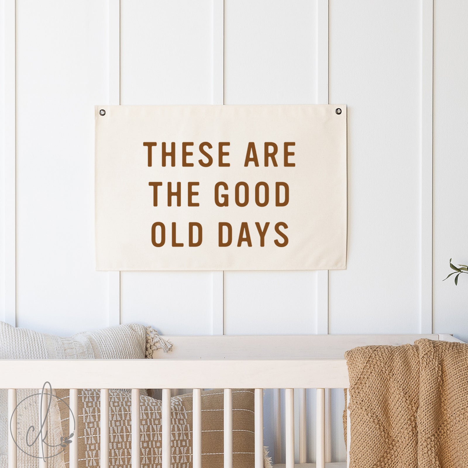 Decorative sign with 'These Are The Good Old Days' text above a crib in a nursery.