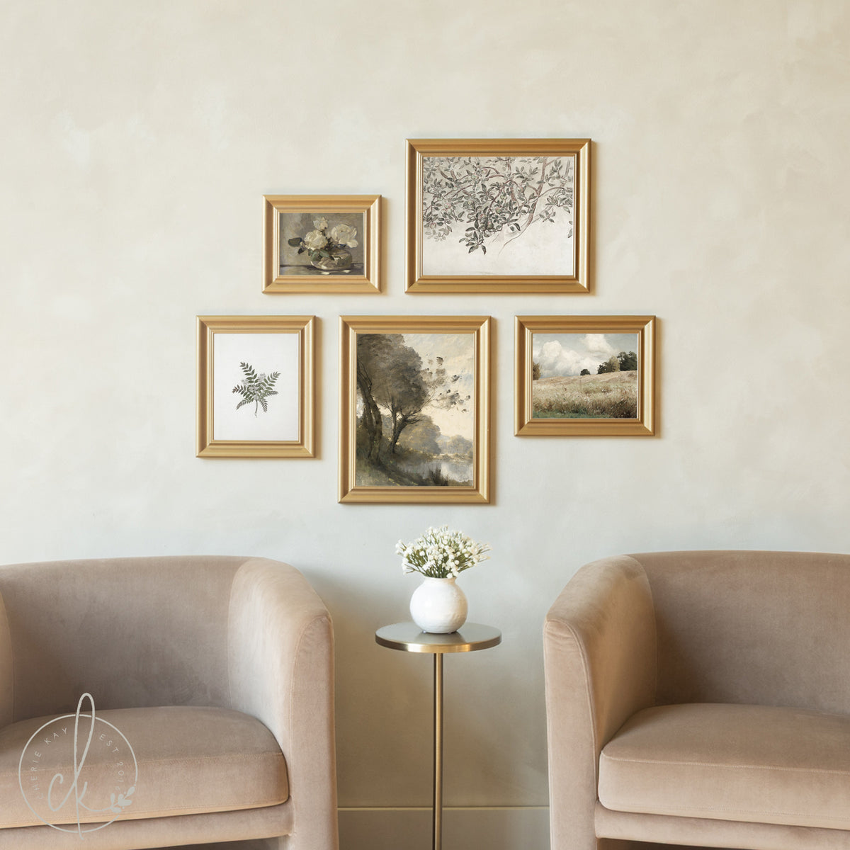 Five gold-framed vintage artworks displayed in a curated gallery wall arrangement above neutral beige armchairs, featuring botanical illustrations, pastoral landscapes, a serene river scene, and a delicate floral still life, creating a cohesive collection of nature-inspired art.