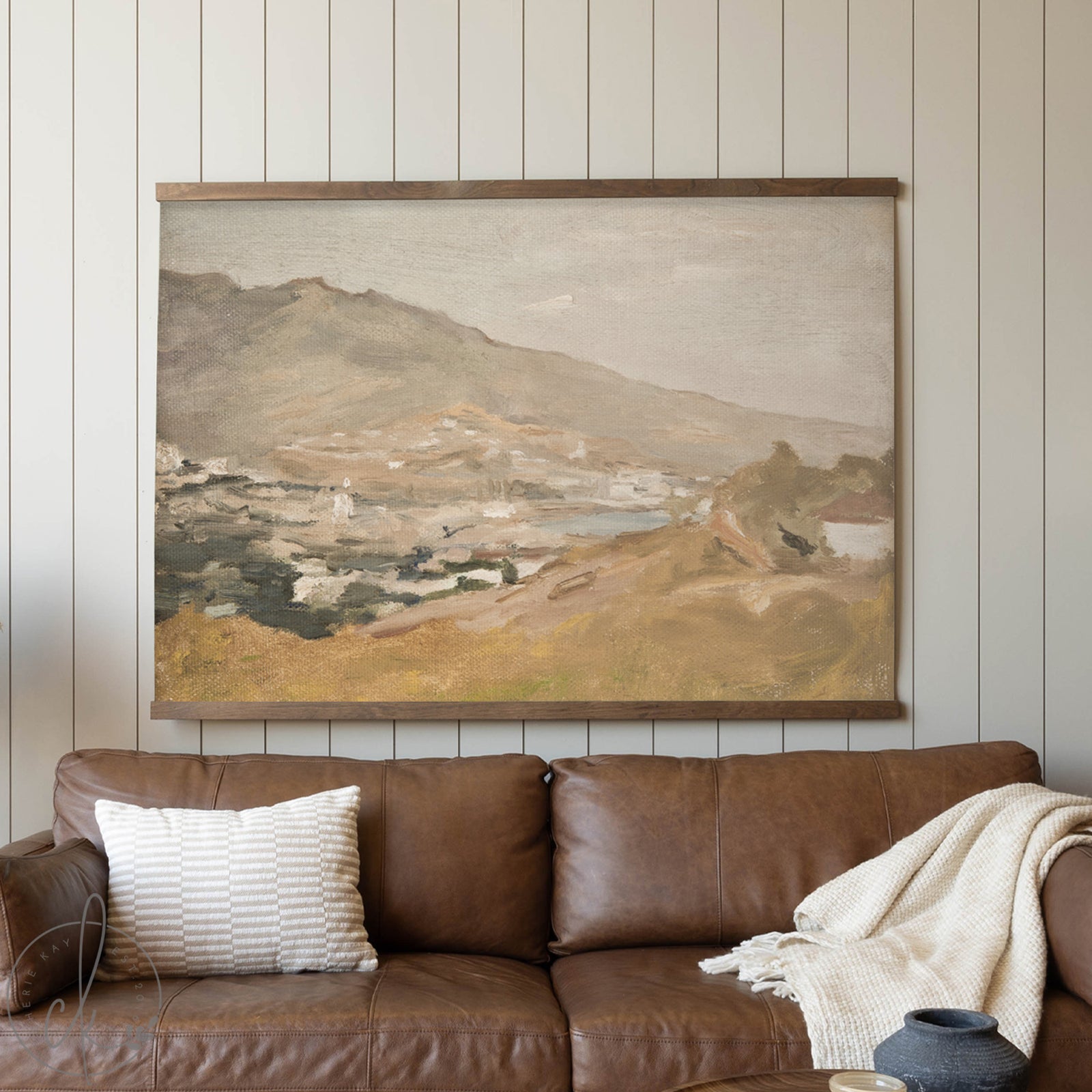 Brown leather sofa with a landscape painting on a wooden wall