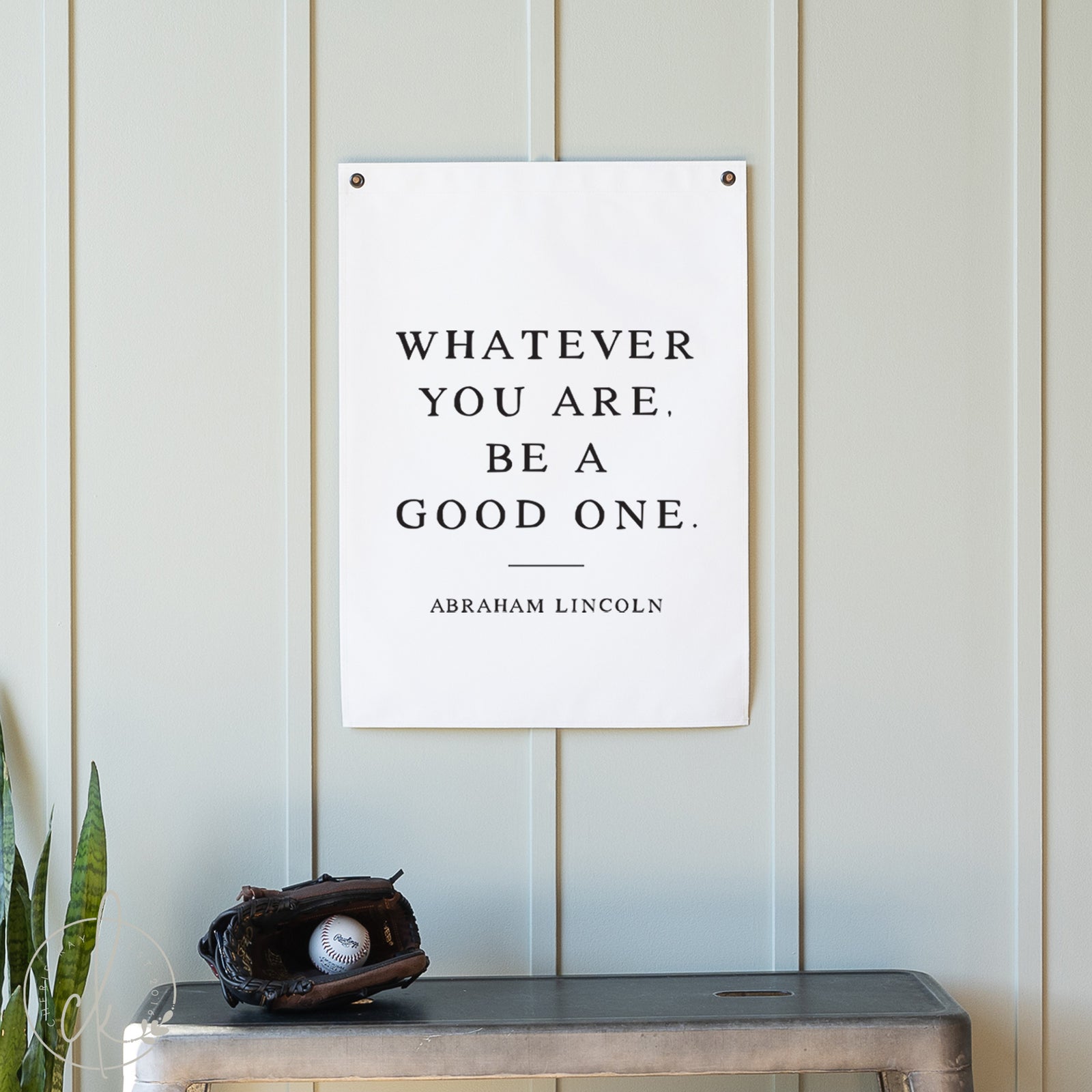 Motivational poster with quote by Abraham Lincoln on a wall above a table with a baseball and glove.