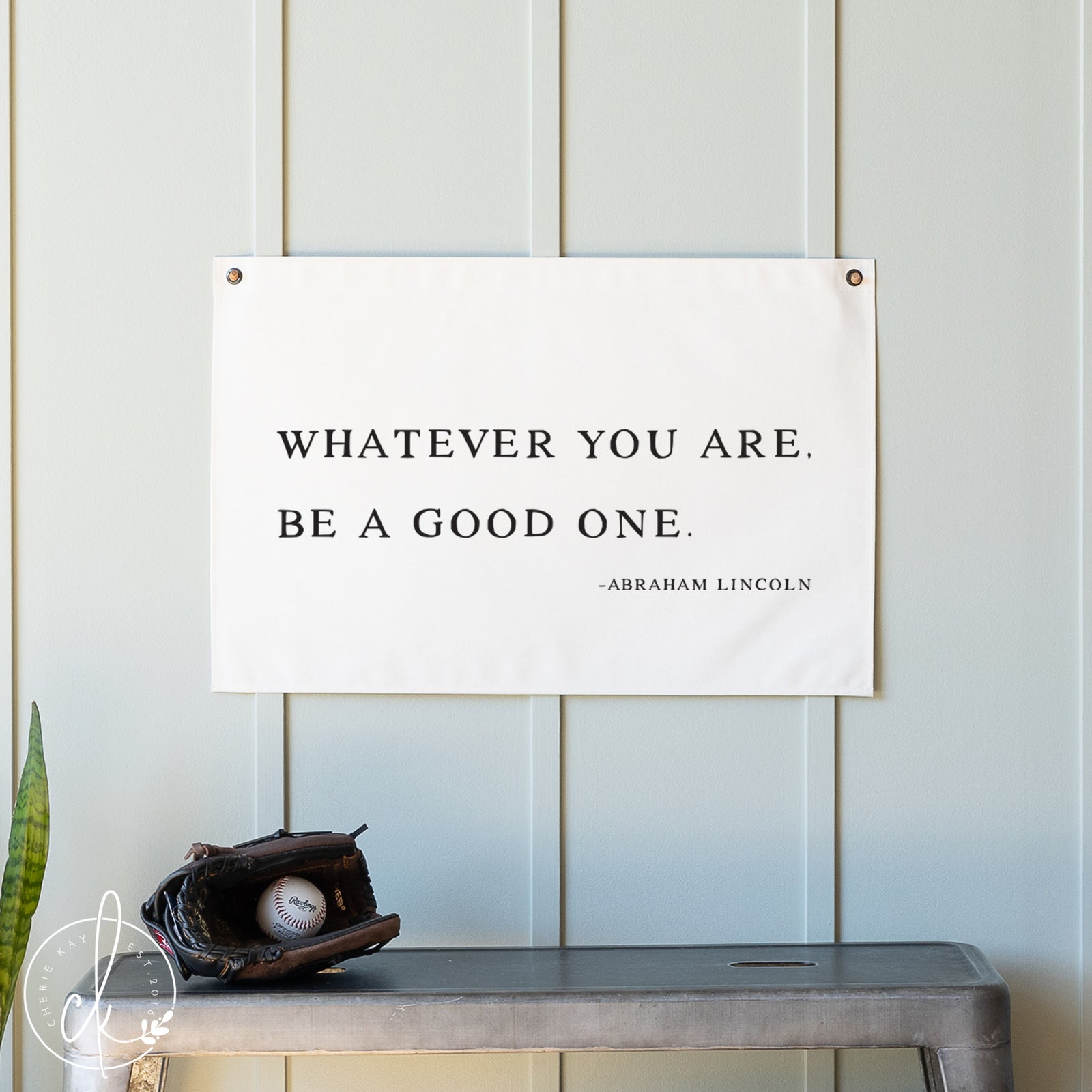 Motivational poster with quote by Abraham Lincoln on a wall with a baseball and glove below.