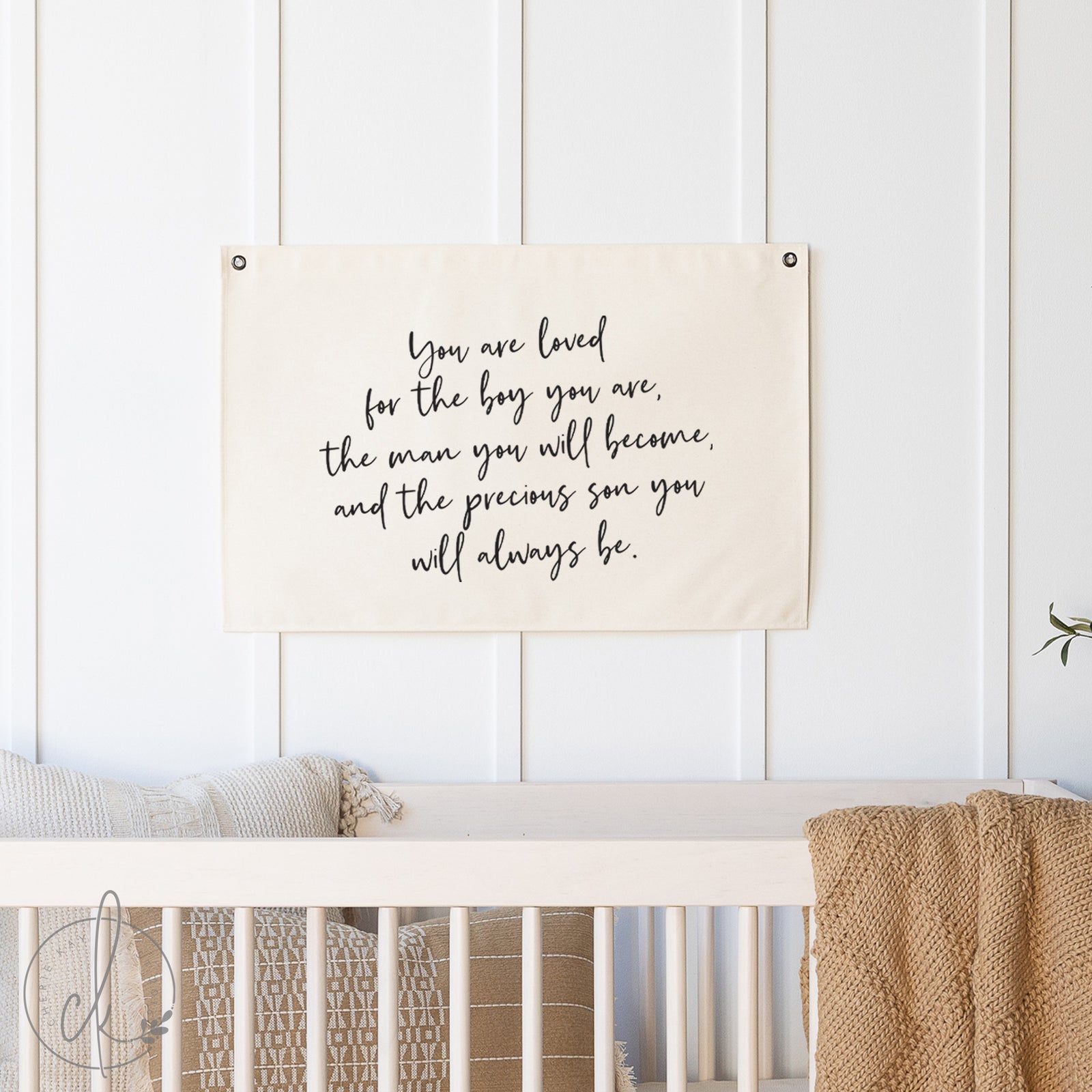 Nursery with a motivational quote on a wall hanging above a crib.