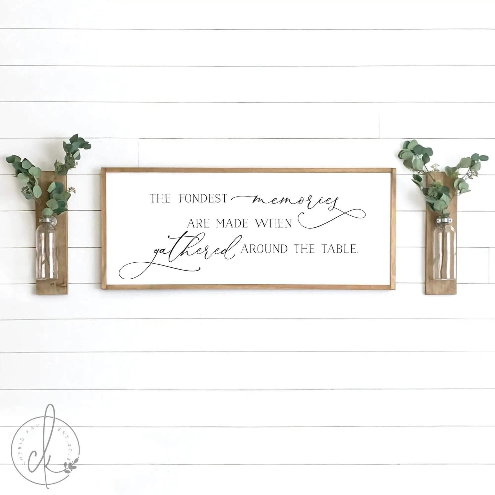 three vases filled with flowers sitting on top of a wall