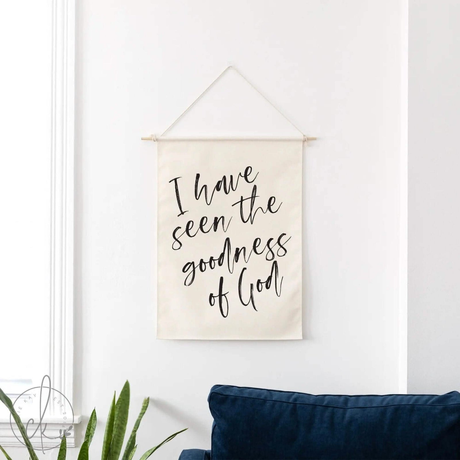 a canvas dowel rod wall hanging on a wall above a blue couch